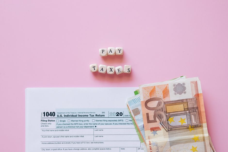Neatly organized flat lay of essential items for a financial go-bag, including a passport, cash, and important documents i...